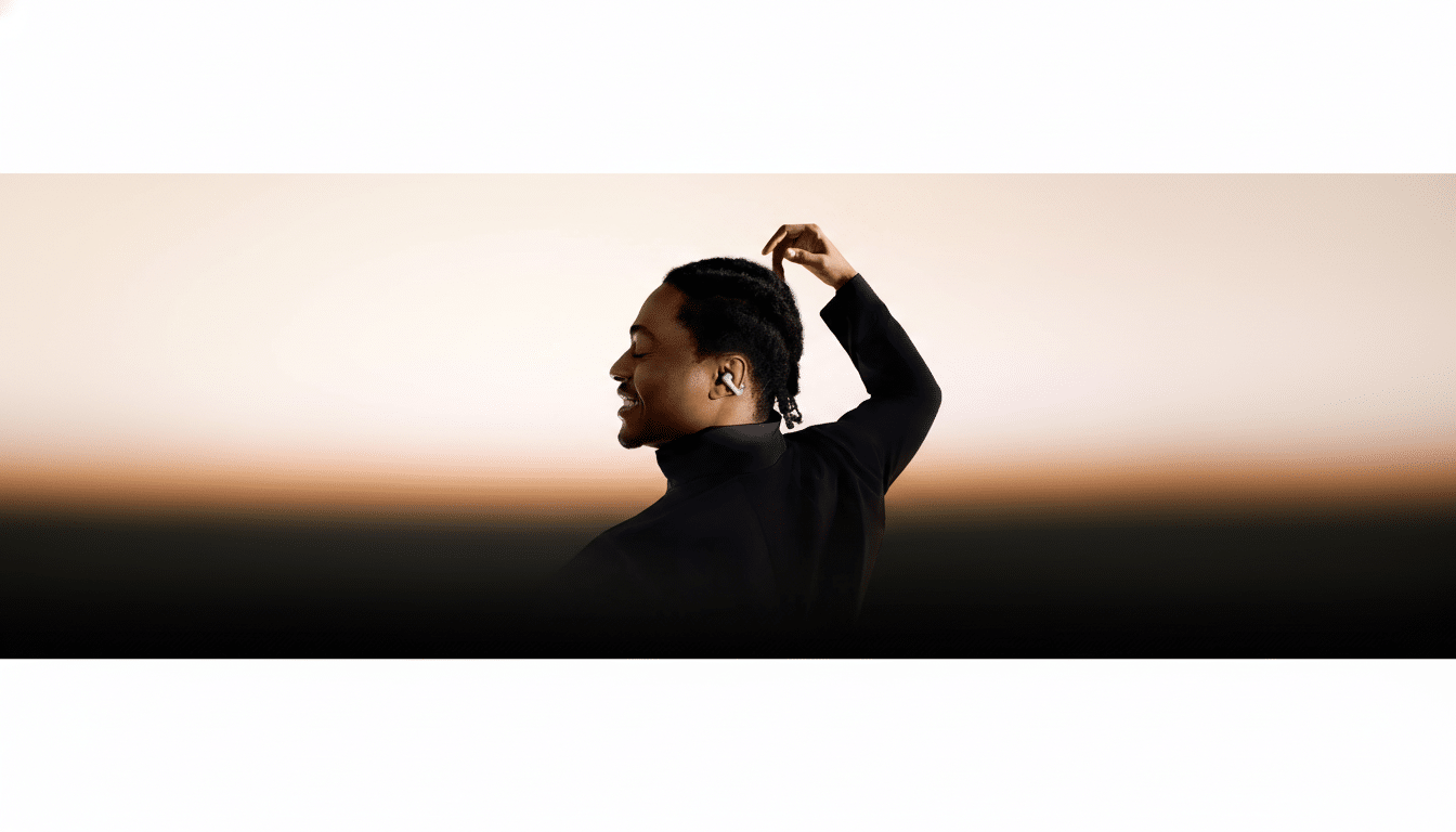 A man with dreadlocks wearing a dark turtleneck and a single earbud, smiling with his eyes closed, against a gradient background.