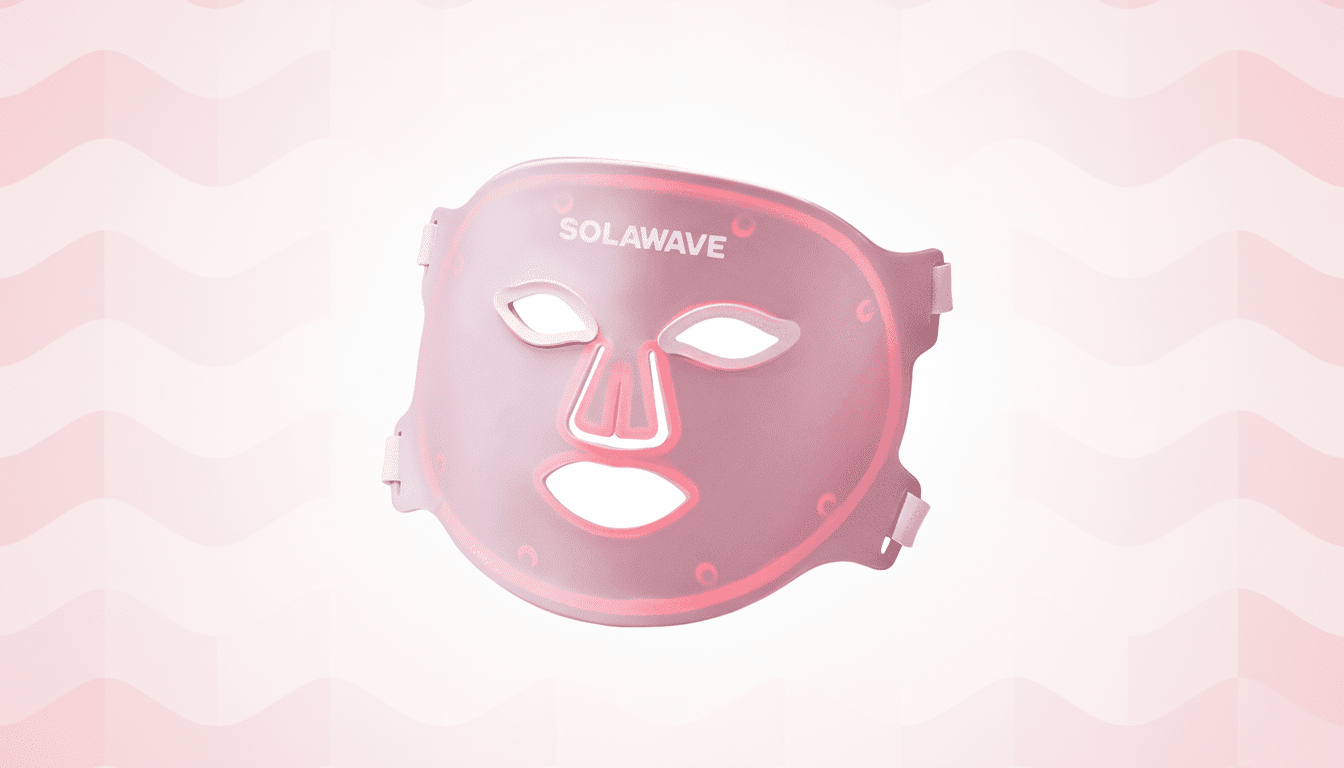 A pink Solawave LED light therapy mask with glowing red lights, set against a soft pink and white wavy gradient background.
