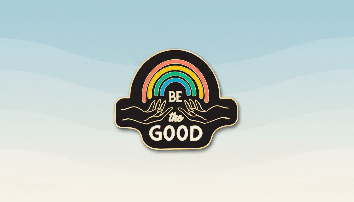 A 16:9 aspect ratio image of a black enamel pin with a rainbow and two hands holding it, with the text BE the GOOD in white, set against a professional flat design background with soft blue and beige wave patterns.