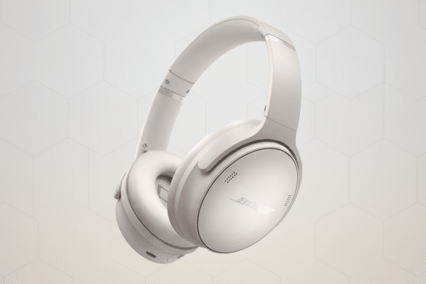 A pair of white Bose noise-cancelling headphones on a light gray background with a subtle hexagonal pattern.