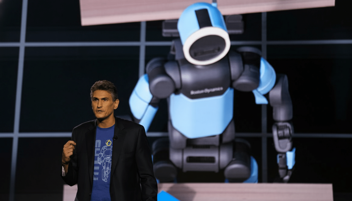 A man in a suit jacket and blue t-shirt stands in front of a large blue and black robot.