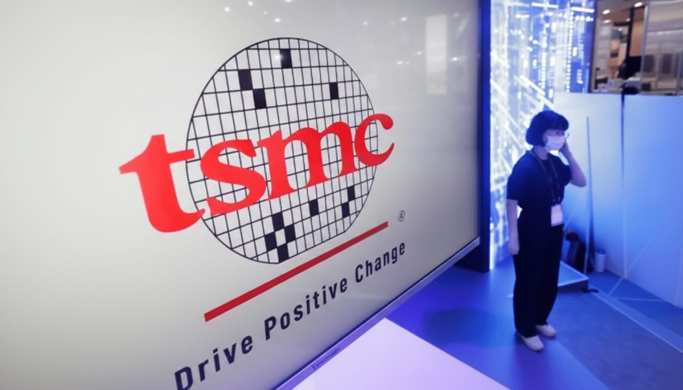 A woman stands next to a large screen displaying the TSMC logo and the slogan Drive Positive Change.