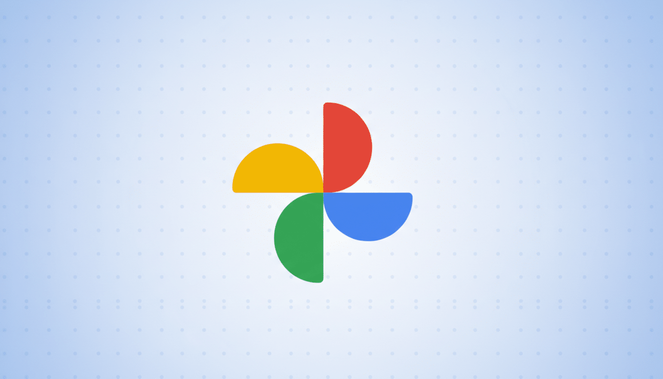 The Google Photos logo, consisting of four colorful pinwheel-like shapes (red, yellow, green, and blue), centered on a light blue background with a subtle dotted pattern.