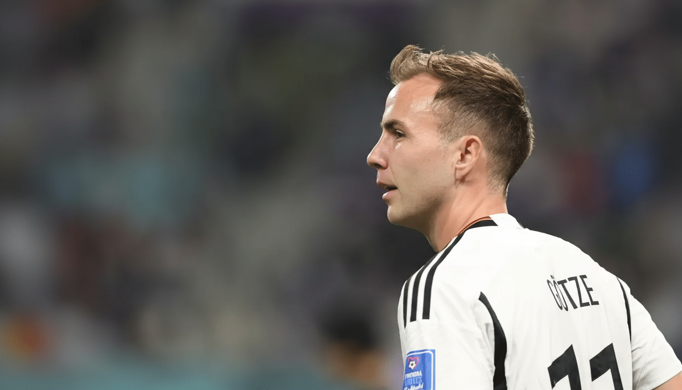 A professional, enhanced image of a male soccer player in a white jersey with GÖTZE and 11 on the back, looking to his right, with a blurred stadium background.