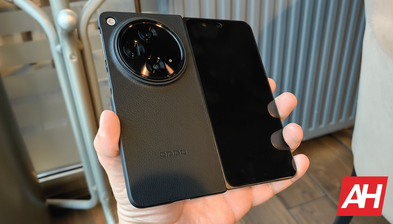 A hand holding an open black foldable smartphone with a large circular camera module on the back.
