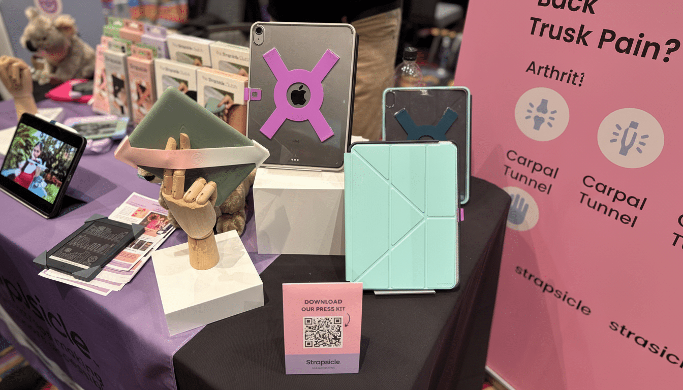 A display of tablet cases and accessories at a trade show booth, featuring various colors and designs, with a pink banner in the background.