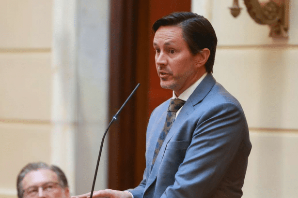 A man in a suit speaking at a podium.