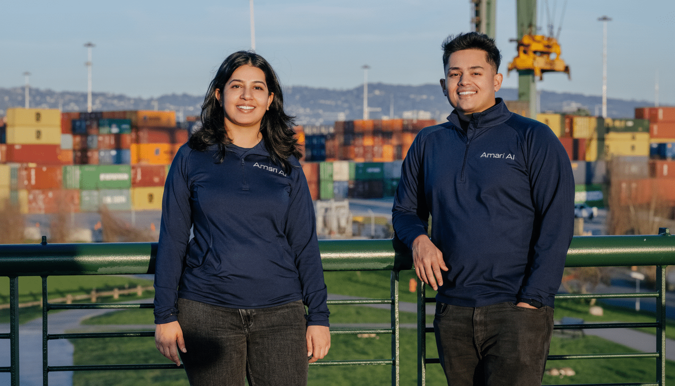 Two people in navy blue shirts standing on a bridge with shipping containers in the background.