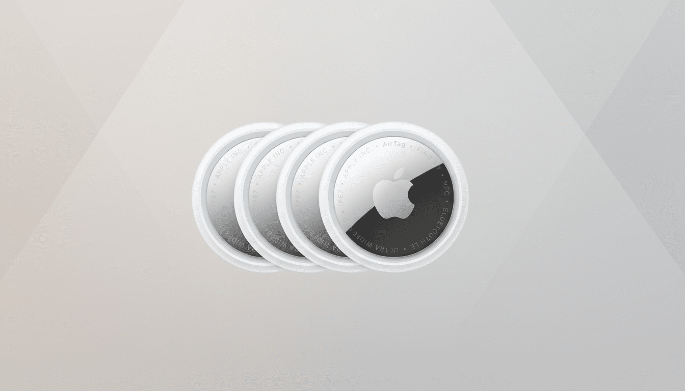 Four Apple AirTags are arranged in a slightly overlapping diagonal line against a soft, gradient background. The AirTags are white with silver accents, and the Apple logo is visible on the front of the foremost AirTag.