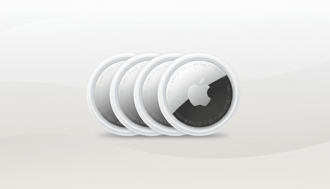 Four Apple AirTags are displayed in a row, with the frontmost AirTag showing its white and silver design with the Apple logo and text details. The background is a subtle gradient from light grey to off-white.