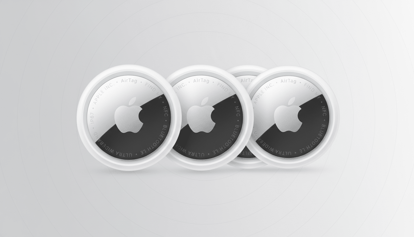 Four Apple AirTags are arranged in a slightly overlapping row, with the frontmost AirTag clearly visible, showcasing its white and silver design with the Apple logo. The background is a professional, soft gray gradient.