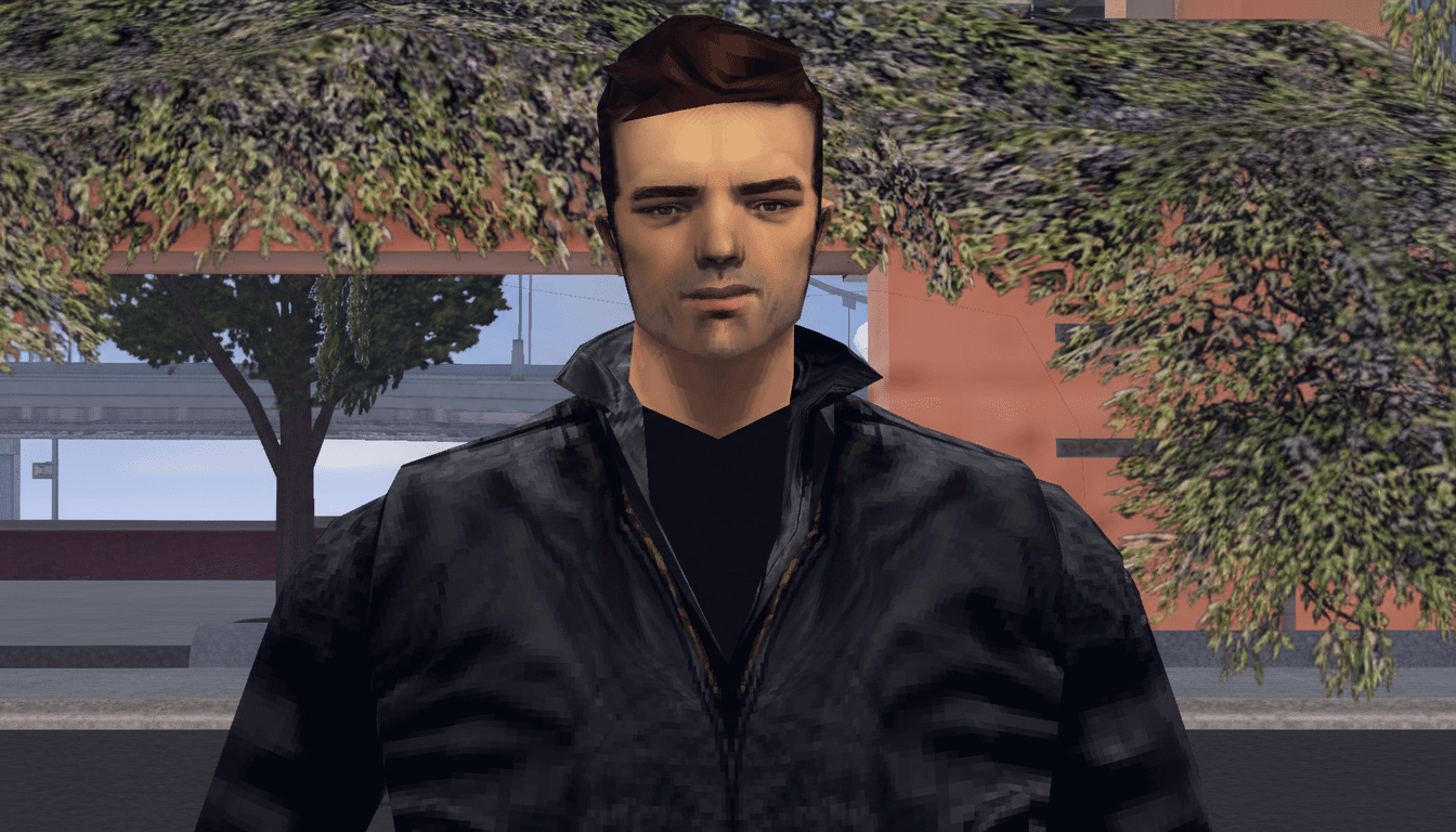 A man with dark hair and a black leather jacket stands in front of a building with trees.