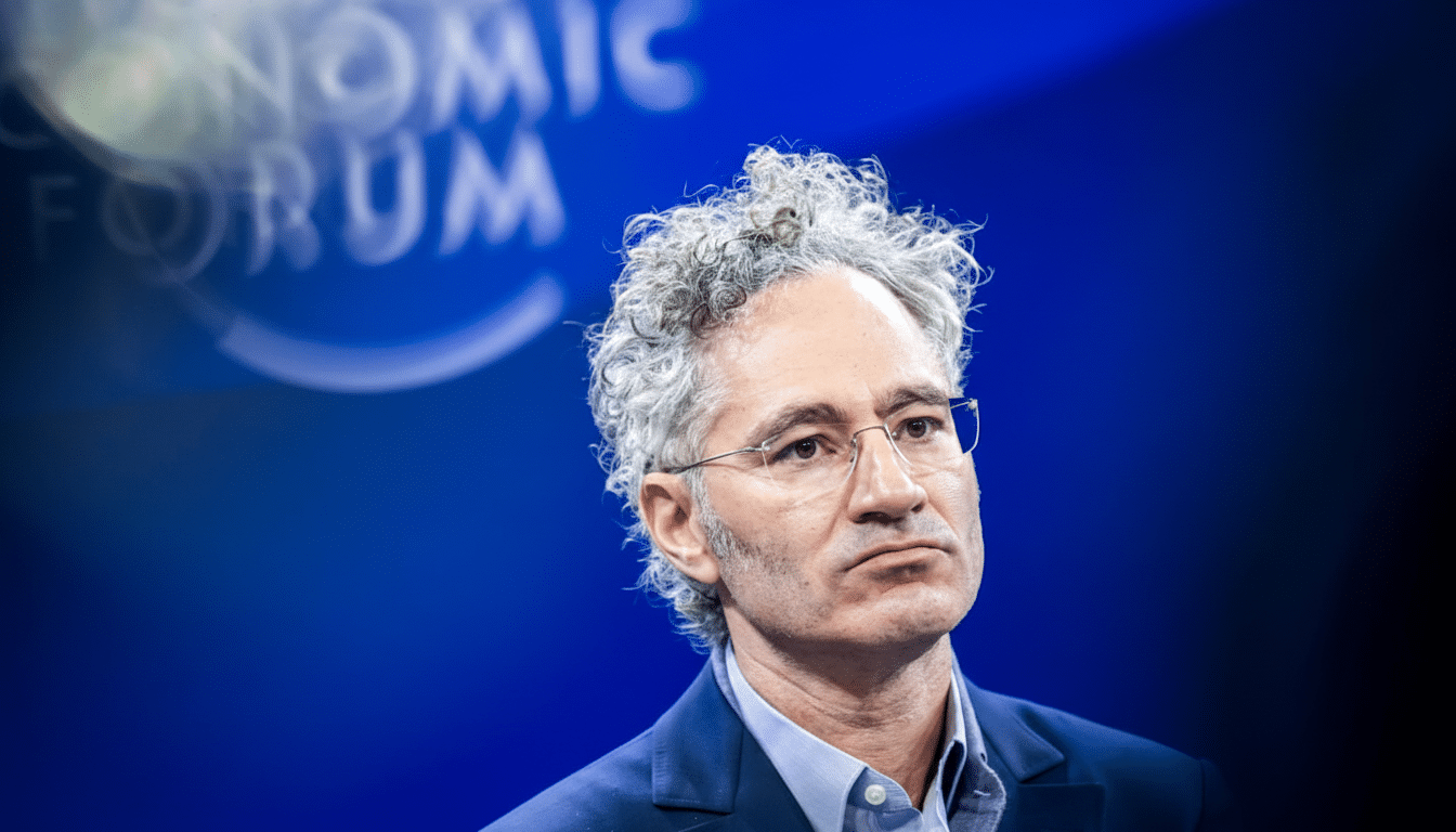 A man with curly grey hair and glasses, wearing a blue suit jacket and light blue collared shirt, looks thoughtfully to the right. The background is a blurred blue with the faint white text WORLD ECONOMIC FORUM visible.