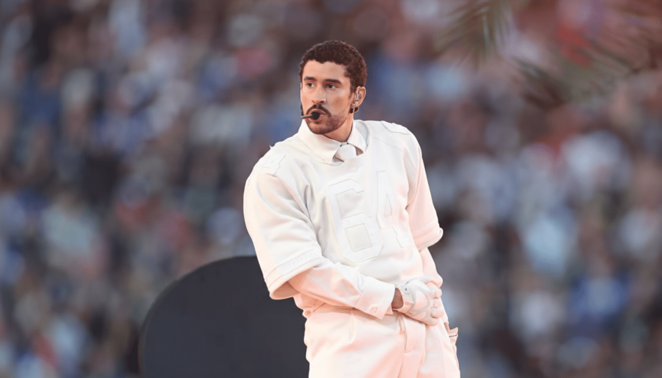 Bad Bunny performing on stage, wearing a light-colored outfit, with a microphone headset, looking to his left.