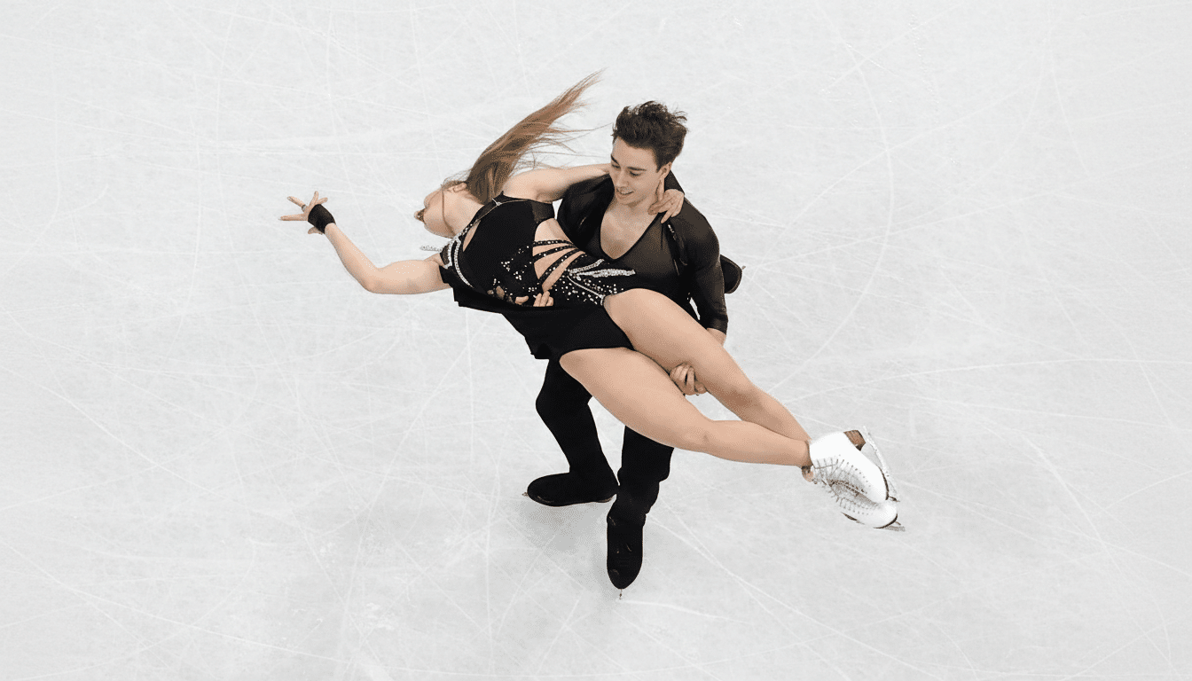 A male and female ice dancer performing a lift on a white ice rink.