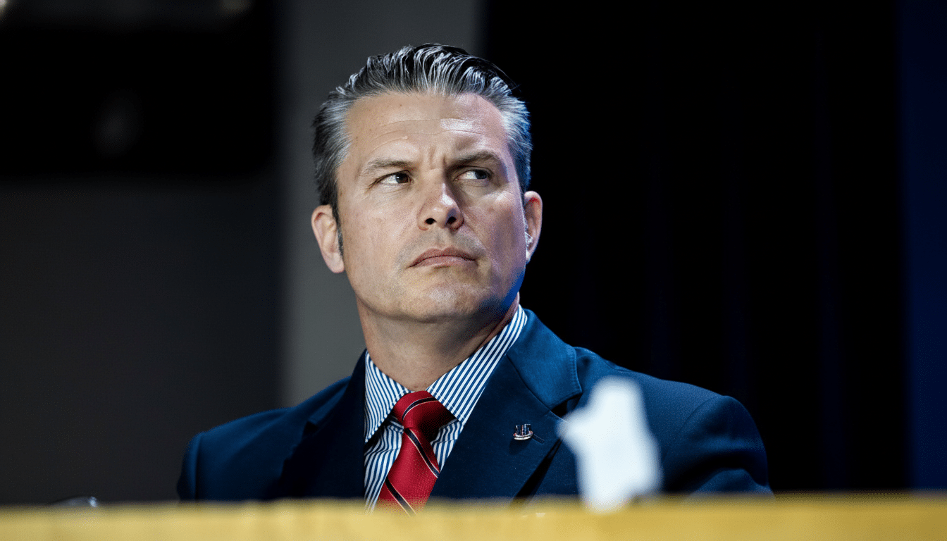 A man in a suit and tie looking to his right, with a dark background.