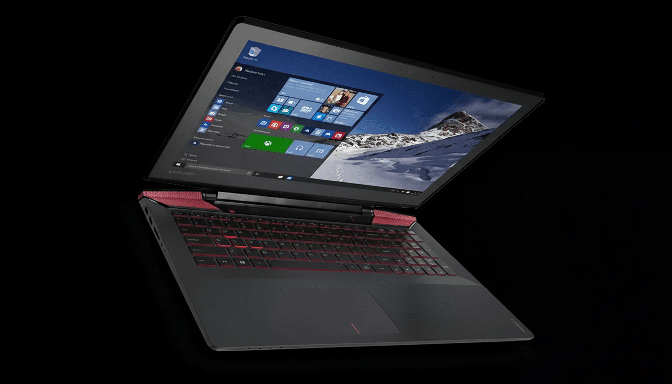 A black and red Lenovo gaming laptop with a glowing red keyboard, angled on a black background. The screen displays the Windows 10 desktop with a snowy mountain wallpaper.