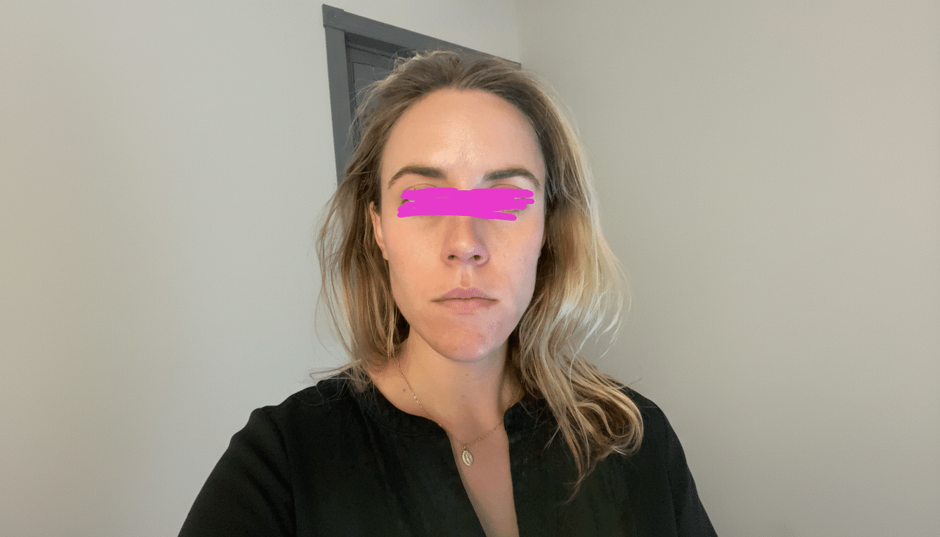 A woman with blonde hair and a black shirt, with a pink bar over her eyes, resized to a 16:9 aspect ratio.