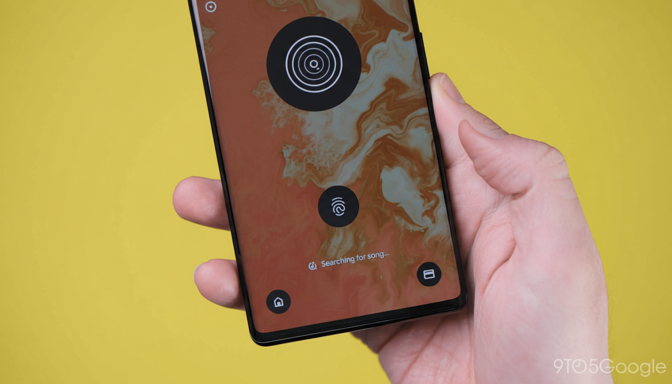A hand holding a smartphone displaying a music recognition app interface.