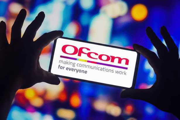 A pair of silhouetted hands holding a smartphone displaying the Ofcom logo and slogan making communications work for everyone against a blurred, colorful background.