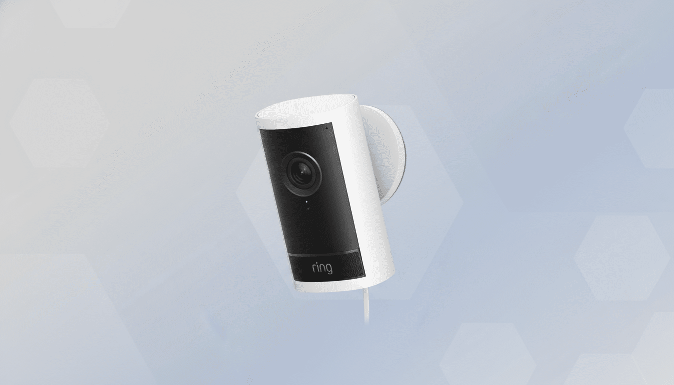 A white Ring security camera with a black face, mounted on a white circular base, set against a professional light blue background with subtle hexagonal patterns.