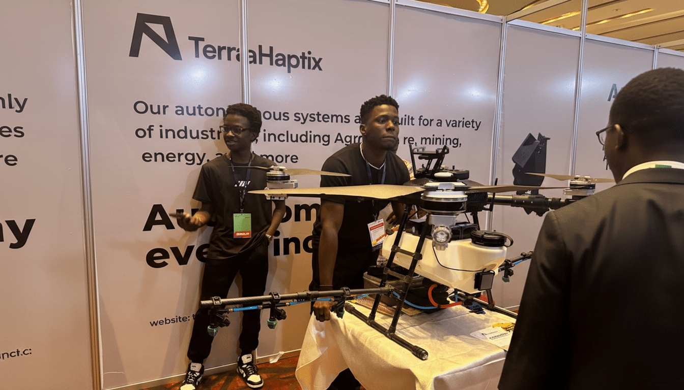 Two men standing next to a large drone at a TerraHaptix booth, with one man looking at the drone and the other looking towards the viewer.