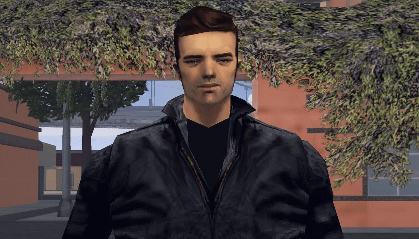 A man with dark hair and a black jacket, standing outdoors with trees and buildings in the background.