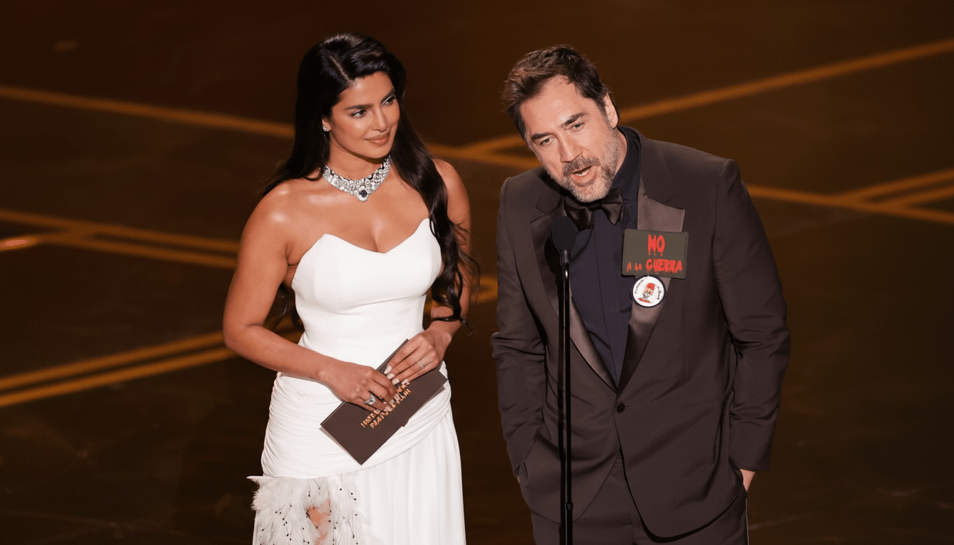 A woman in a white dress and a man in a suit standing on a stage with a microphone, resized to a 16:9 aspect ratio.