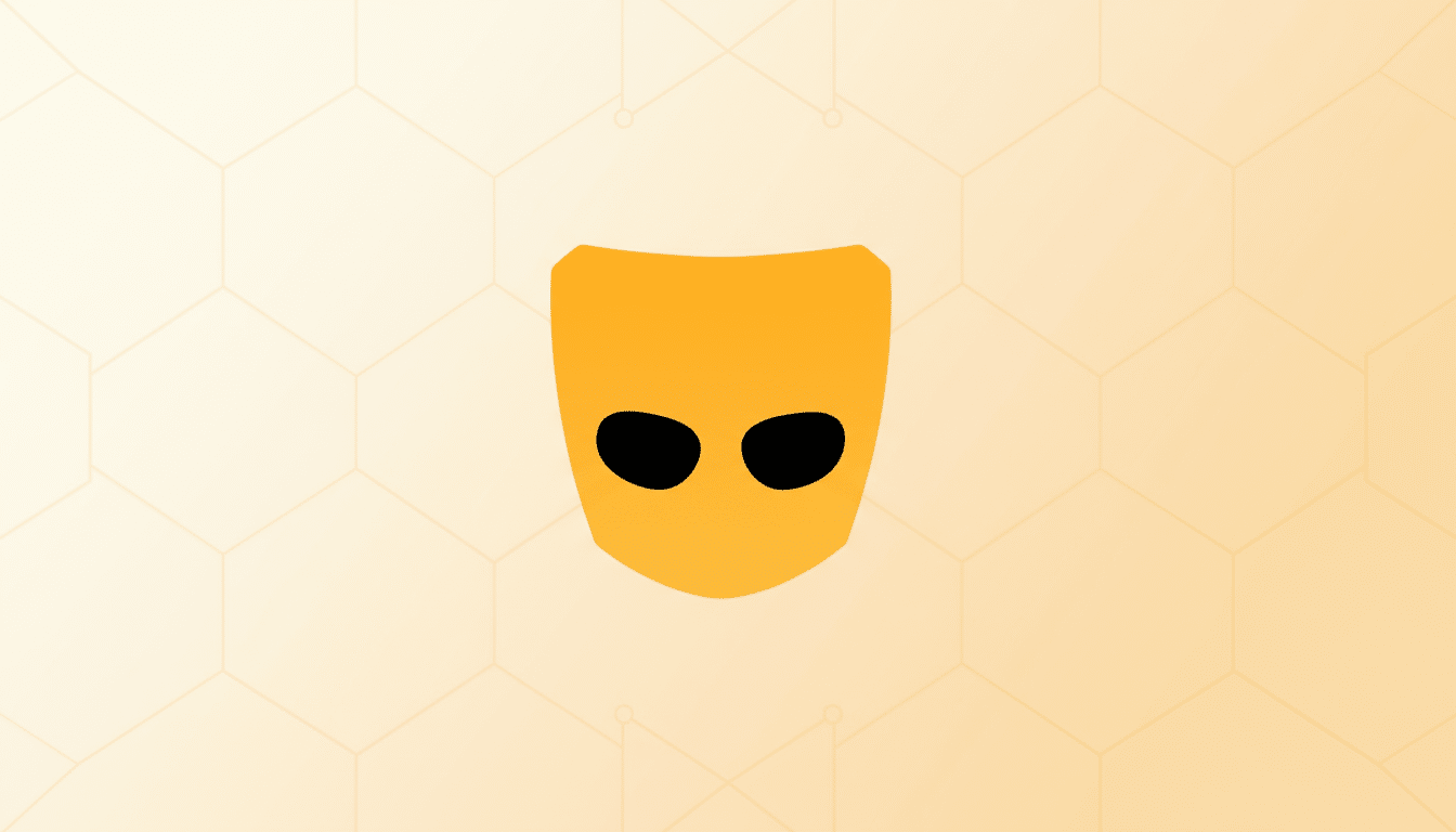 The Grindr logo, a stylized yellow mask with two black eyeholes, centered on a light orange background with a subtle hexagonal pattern.