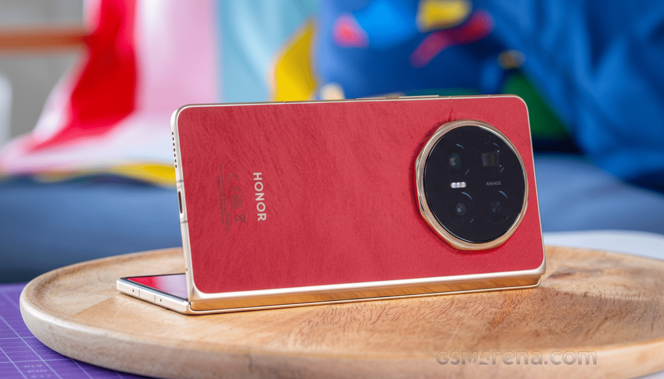 A red Honor smartphone with a large circular camera module on the back, resting on a wooden tray.
