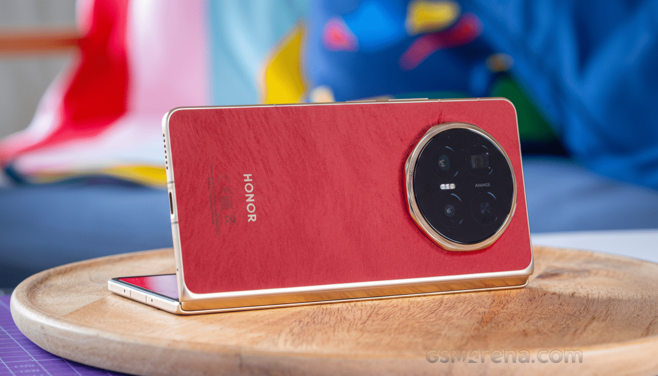 A red Honor smartphone with a large circular camera module on the back, resting on a wooden surface.