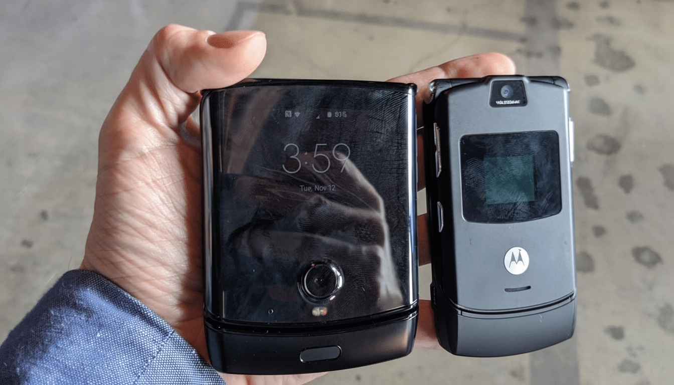A hand holding two Motorola Razr phones, one modern and one classic, side-by-side.