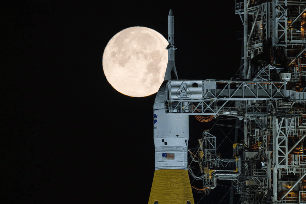 A full moon rises behind the Artemis I Space Launch System rocket at Launch Complex 39B at NASAs Kennedy Space Center in Florida.