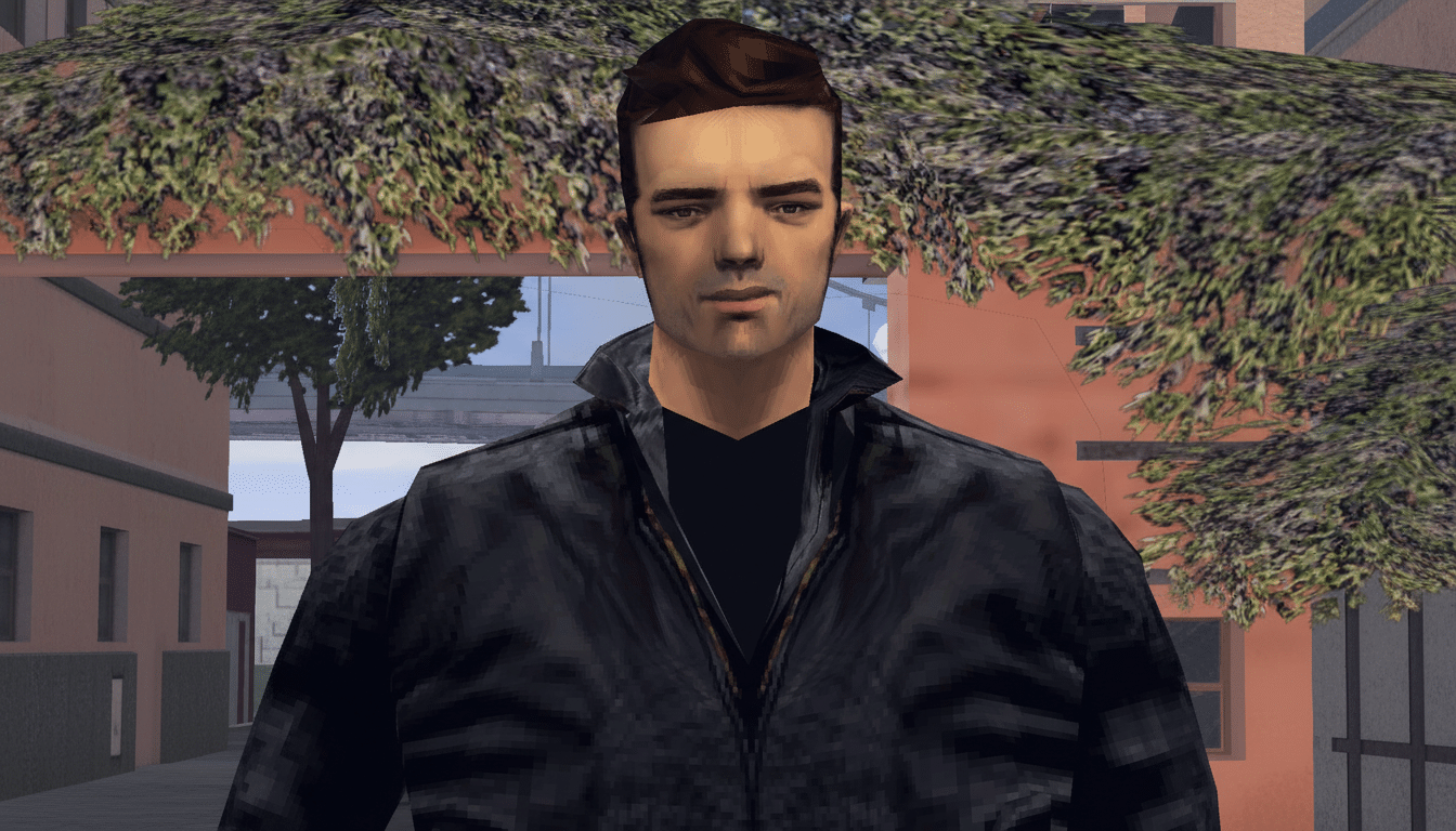 A man with dark hair and a black jacket, standing outdoors with trees and buildings in the background.